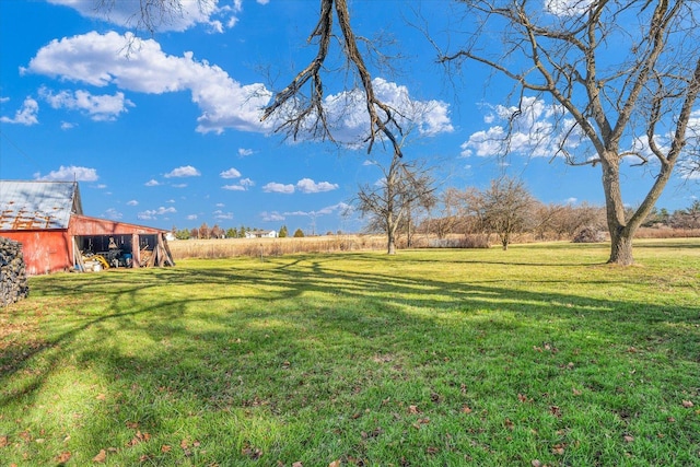 view of yard with a rural view, an outdoor structure, and a pole building