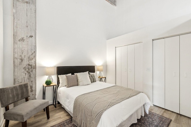 bedroom with two closets and light wood-style floors