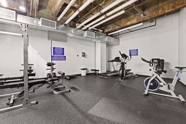 exercise room with baseboards and visible vents