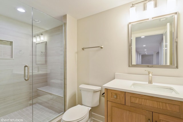 full bath featuring toilet, a shower stall, and vanity