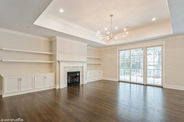 unfurnished living room featuring dark wood-style floors, a raised ceiling, and a premium fireplace