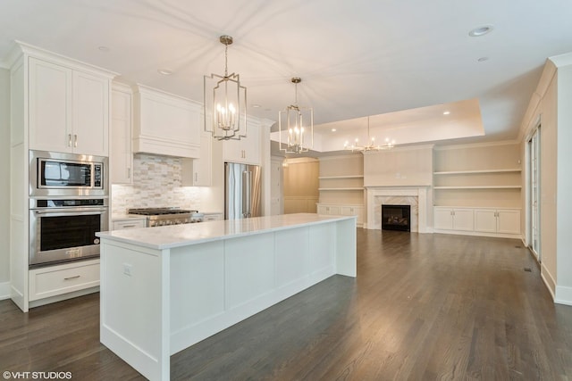 kitchen featuring dark wood-style floors, a large island, a premium fireplace, appliances with stainless steel finishes, and white cabinetry