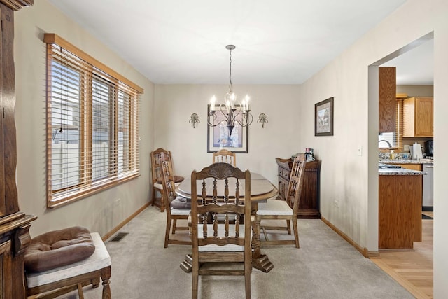 carpeted dining space featuring an inviting chandelier