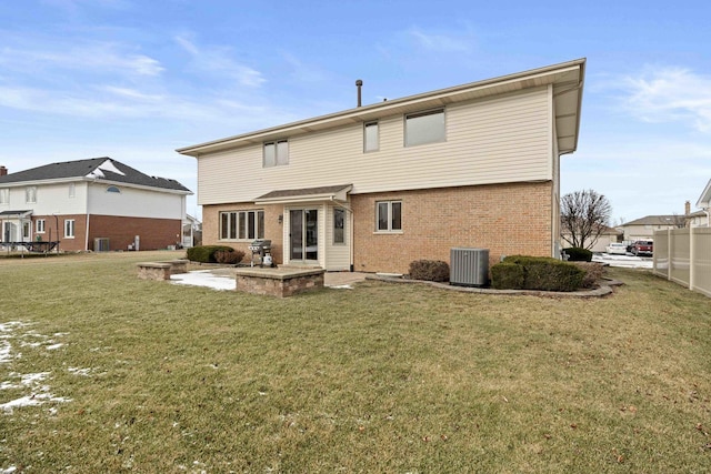 back of property with a patio, a lawn, and central AC