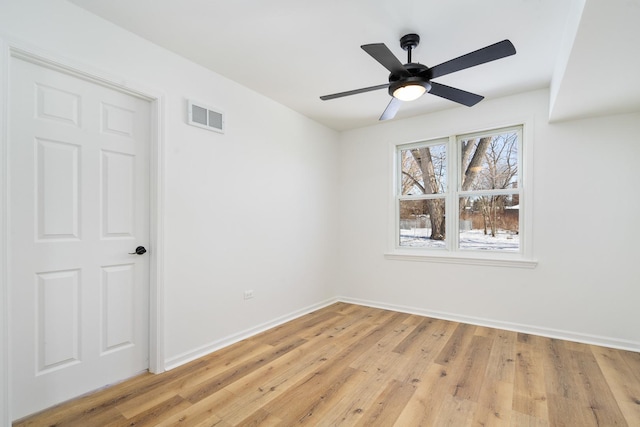 empty room featuring light wood finished floors, baseboards, visible vents, and a ceiling fan