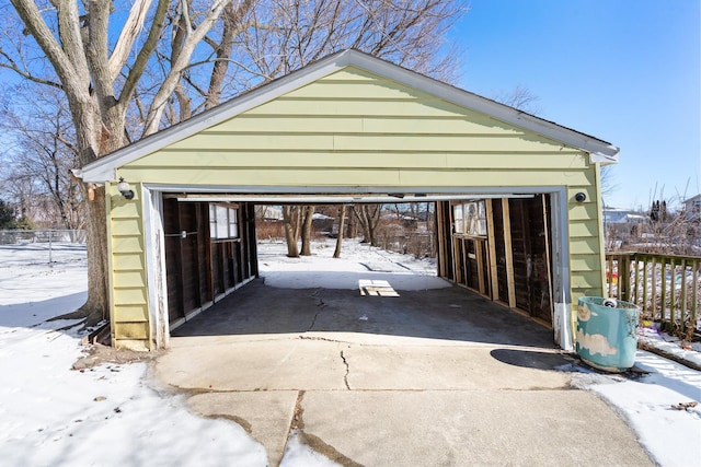 snow covered garage with a detached garage