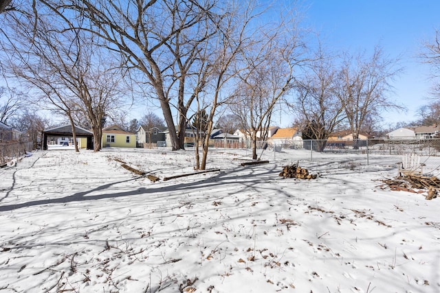 yard layered in snow with fence and a residential view