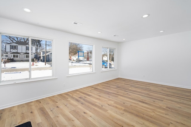 spare room featuring baseboards, visible vents, light wood-style flooring, and recessed lighting