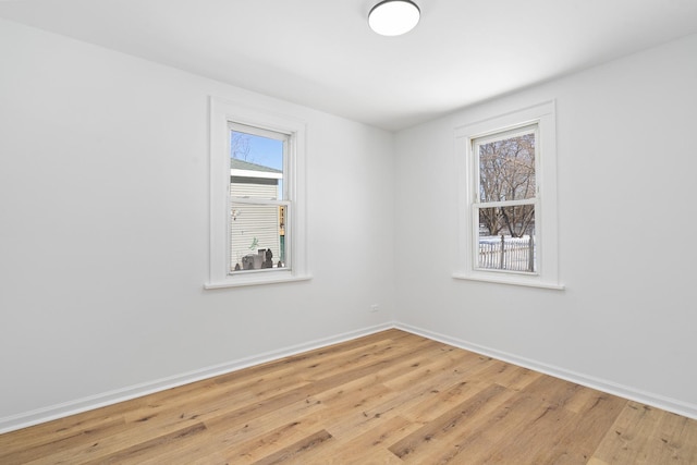 empty room with light wood-style floors and baseboards