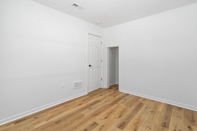 unfurnished room with visible vents, light wood-style flooring, and baseboards