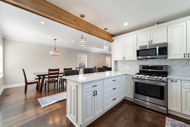 kitchen featuring kitchen peninsula, appliances with stainless steel finishes, white cabinets, and hanging light fixtures