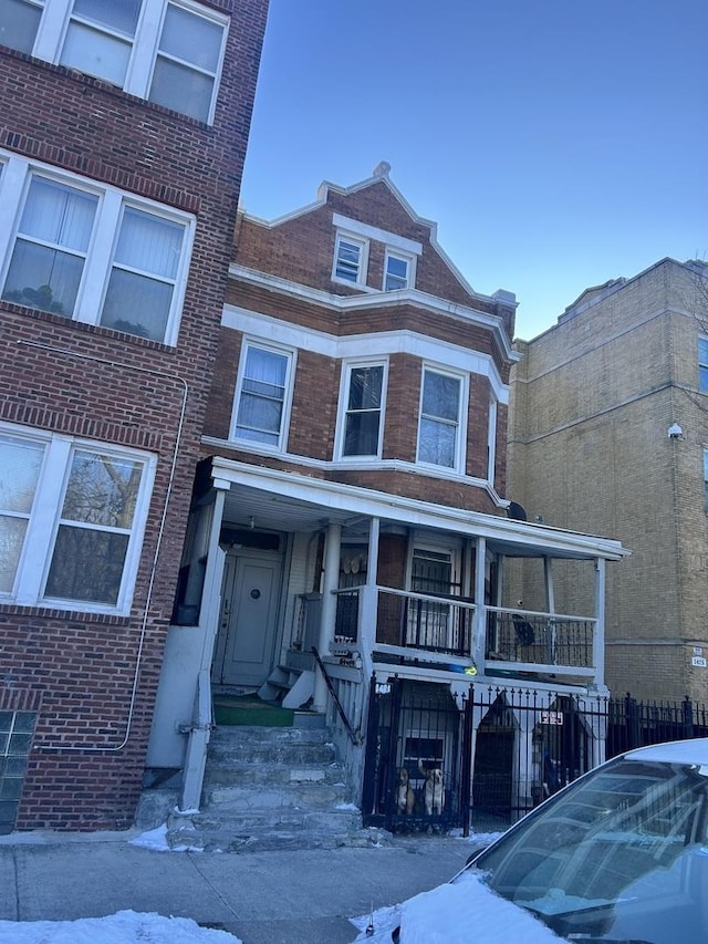 view of front of property with brick siding and fence