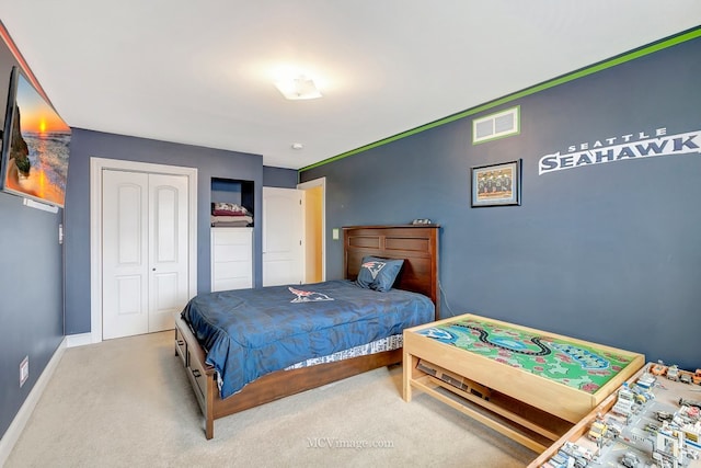 carpeted bedroom featuring a closet, visible vents, and baseboards