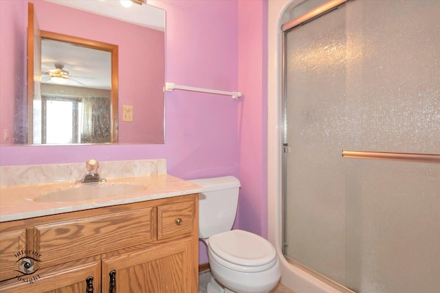 bathroom featuring toilet, a stall shower, and vanity