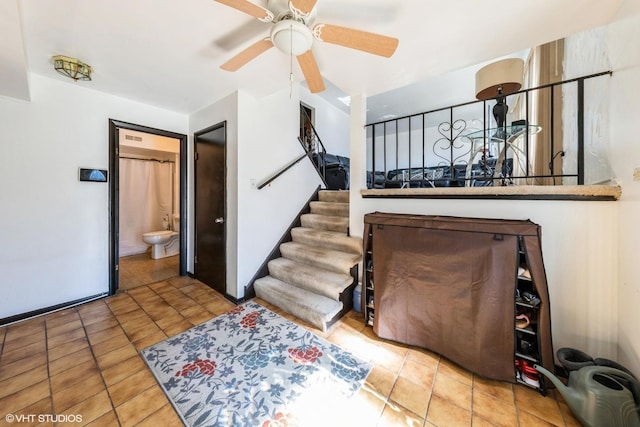 staircase featuring ceiling fan and tile patterned floors