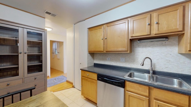 8640 Waukegan Rd Unit 227, Morton Grove, IL 60053 - kitchen featuring stainless steel dishwasher, a sink, dark countertops, decorative backsplash, and light tile patterned floors