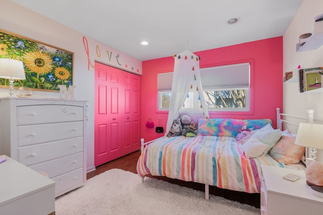 bedroom with wood finished floors, recessed lighting, and a closet