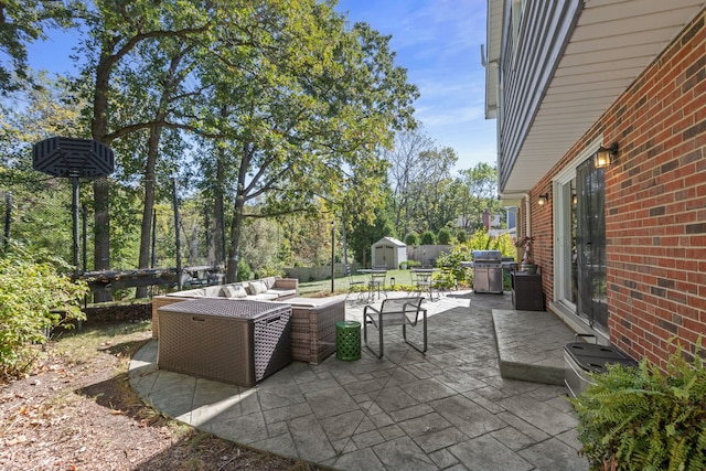 view of patio featuring outdoor lounge area, an outbuilding, area for grilling, and a storage unit