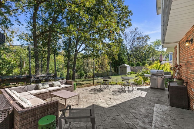 view of patio featuring a storage unit, an outbuilding, fence, a grill, and outdoor lounge area