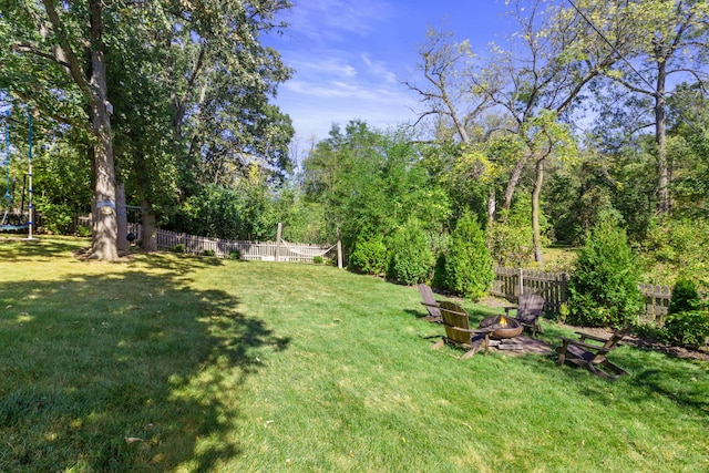 view of yard with an outdoor fire pit, a trampoline, and fence