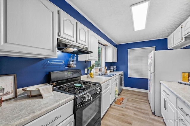 kitchen with black range with gas cooktop, freestanding refrigerator, a sink, under cabinet range hood, and stainless steel dishwasher