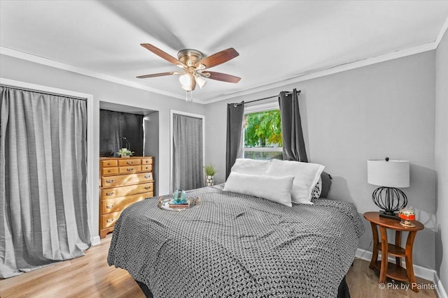 bedroom featuring baseboards, ceiling fan, light wood-style flooring, and crown molding