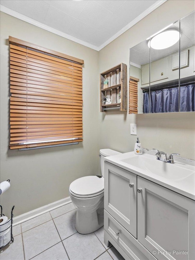 bathroom featuring toilet, vanity, baseboards, tile patterned floors, and crown molding