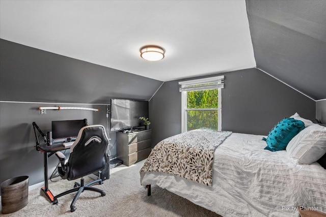 carpeted bedroom featuring lofted ceiling and baseboards