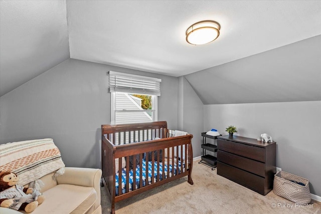 carpeted bedroom featuring vaulted ceiling and baseboards