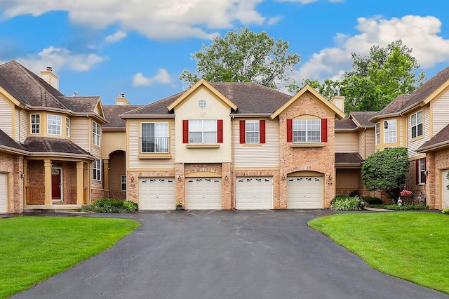 view of property featuring a garage, a front yard, and driveway