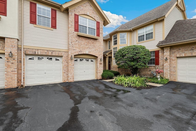 view of front of property with a garage, driveway, and brick siding