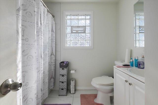 bathroom featuring toilet, baseboards, and vanity