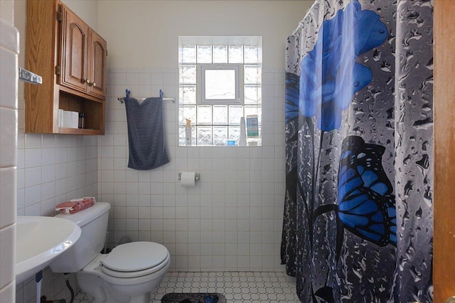 full bath featuring tile walls, tile patterned flooring, toilet, and a shower stall