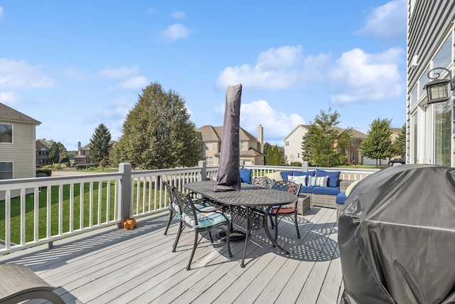 wooden deck featuring a lawn, an outdoor hangout area, and grilling area