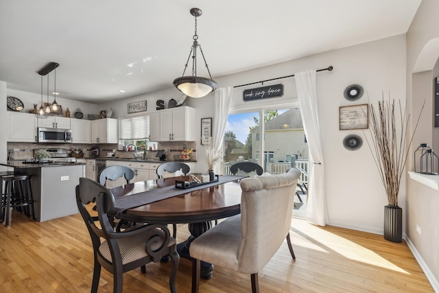 dining space with sink, plenty of natural light, and light hardwood / wood-style floors