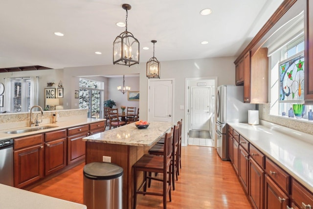 kitchen with an inviting chandelier, a wealth of natural light, a sink, and a center island