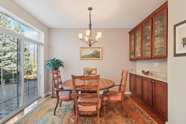 dining space featuring light wood-style floors, baseboards, and a chandelier