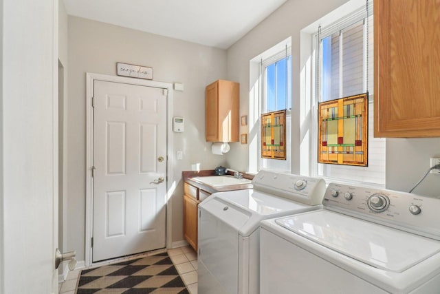 clothes washing area featuring light tile patterned floors, washing machine and dryer, a sink, baseboards, and cabinet space