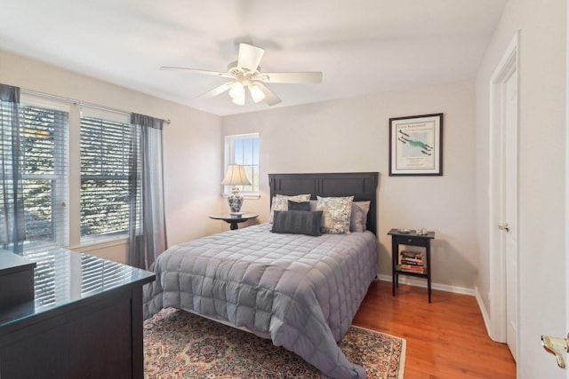 bedroom with a ceiling fan, baseboards, and wood finished floors