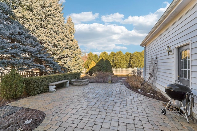 view of patio / terrace with a fire pit, fence, and grilling area