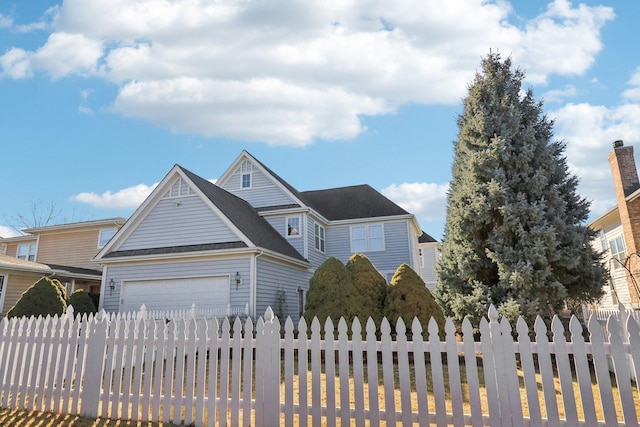 view of front of house featuring an attached garage and fence