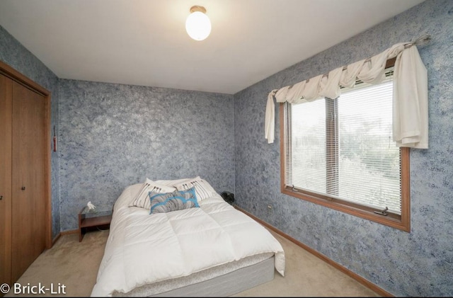 carpeted bedroom featuring wallpapered walls and baseboards