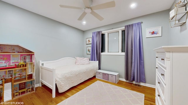 bedroom with visible vents, baseboards, and wood finished floors