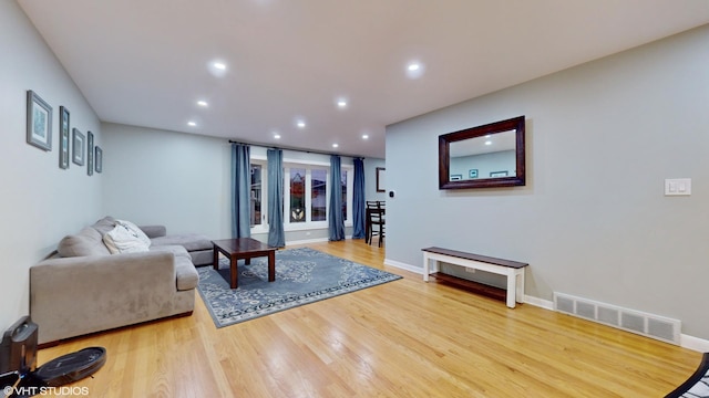 living room featuring recessed lighting, visible vents, baseboards, and wood finished floors