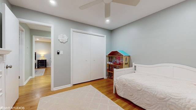 bedroom featuring a closet, baseboards, wood finished floors, and recessed lighting