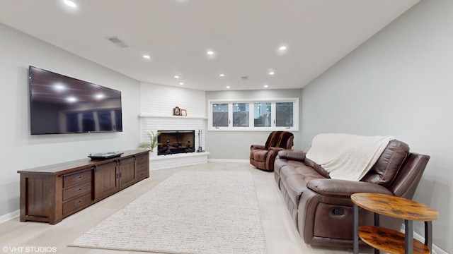 living area with baseboards, a brick fireplace, visible vents, and recessed lighting