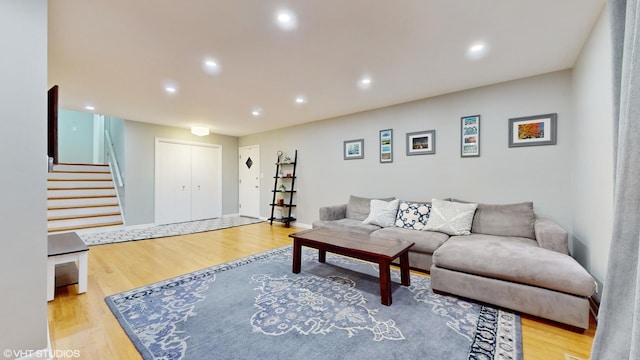 living area with baseboards, stairway, wood finished floors, and recessed lighting