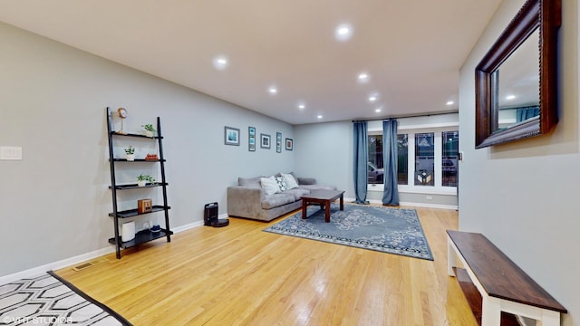 living room featuring baseboards, wood finished floors, visible vents, and recessed lighting