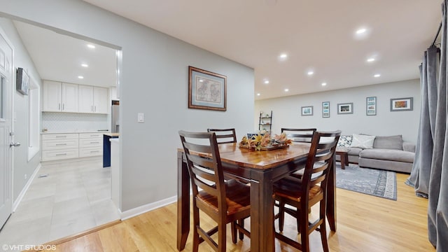 dining area featuring light wood finished floors, baseboards, and recessed lighting