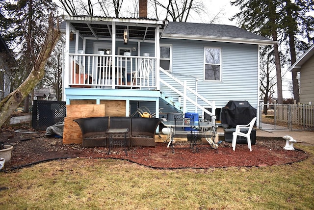 rear view of house with a yard, fence, a chimney, and stairs